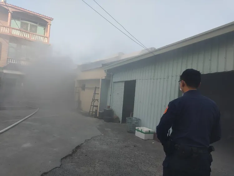 平房一樓冒出大量濃煙，警方與消防人員獲報趕到現場進行搶救。讀者提供