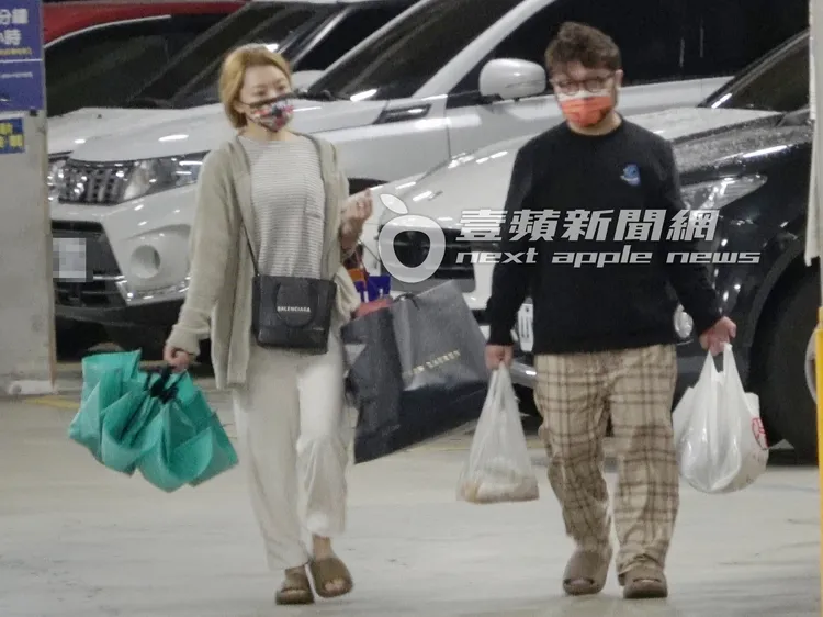 納豆（右）看來有些吃力的提著2袋食材下車，女友依依緊跟在旁提著好幾袋東西。特勤中心攝
