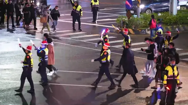 戴聖誕帽的警員，走在民眾人群前，讓民眾安心過馬路。新北市警局提供