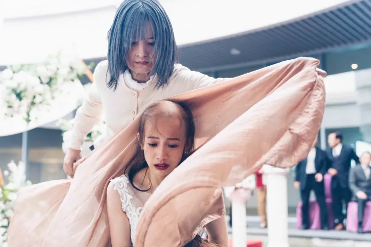 簡嫚書（前）為戲戴禿頭頭套，吳子霏上前解救難堪場面。公視提供