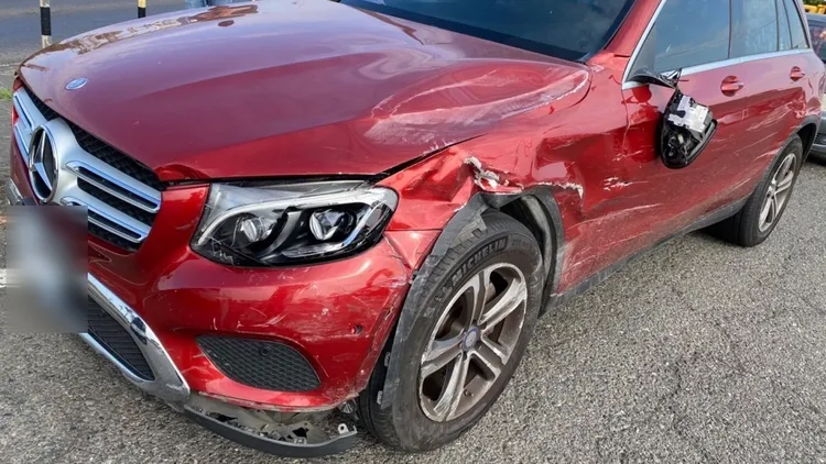 賓士休旅車左側車身，多處嚴重刮損、板金凹陷。民眾提供