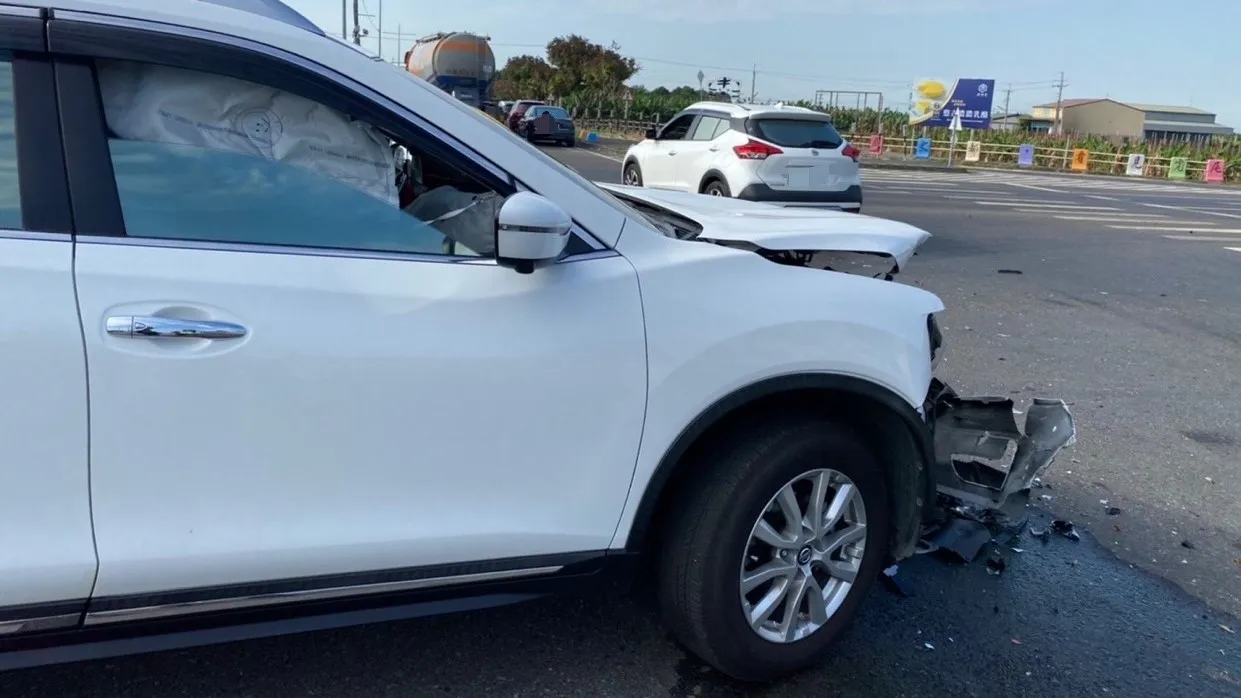 王婦的白色休旅車前座安全氣囊爆開，車頭毀損嚴重。民眾提供
