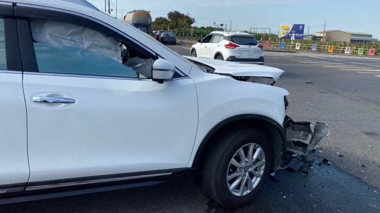 王婦的白色休旅車前座安全氣囊爆開，車頭毀損嚴重。民眾提供