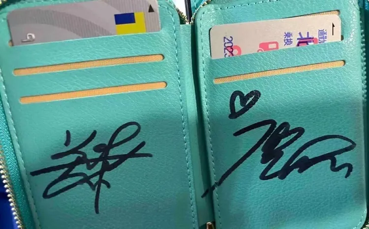 鹿晗與關曉彤與認出2人的粉絲在皮夾上簽名。翻攝羊就是咩咩叫微博