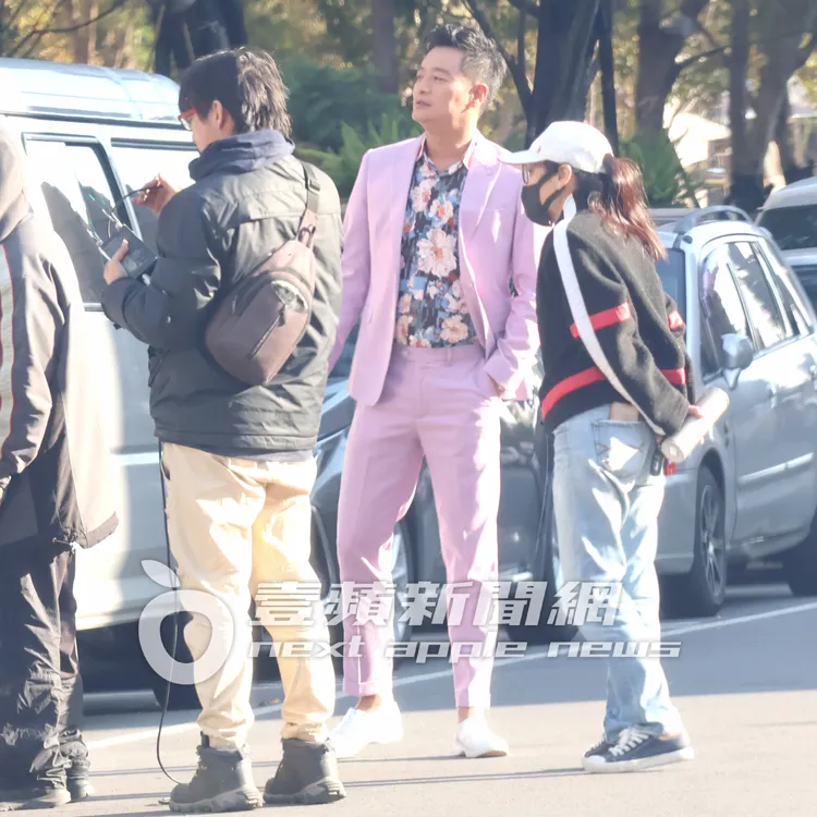 林佑星（中）穿著一身粉紅色花襯衫西裝忙拍戲。特勤中心攝