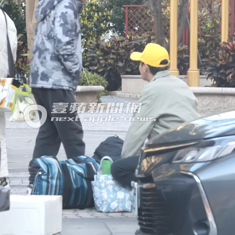 三立一哥陳冠霖走到行李堆，蹲在地上從包包內掏出一盒香菸。特勤中心攝