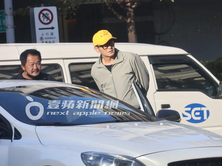 三立一哥陳冠霖（右）頭戴八里無極宮帽子，站在轎車旁等戲。特勤中心攝