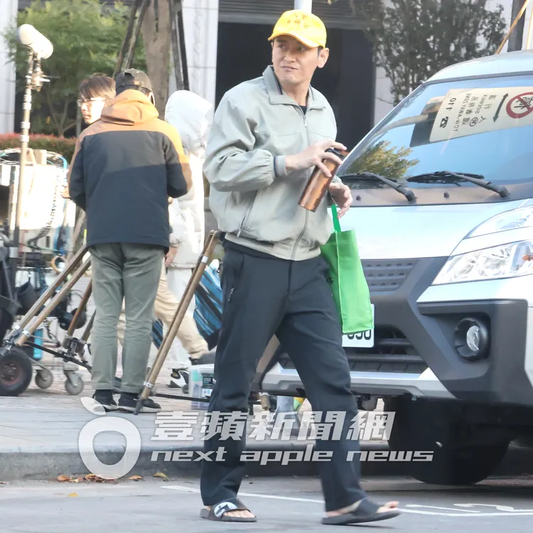 頭戴宮廟帽的陳冠霖穿著拖鞋過馬路。特勤中心攝