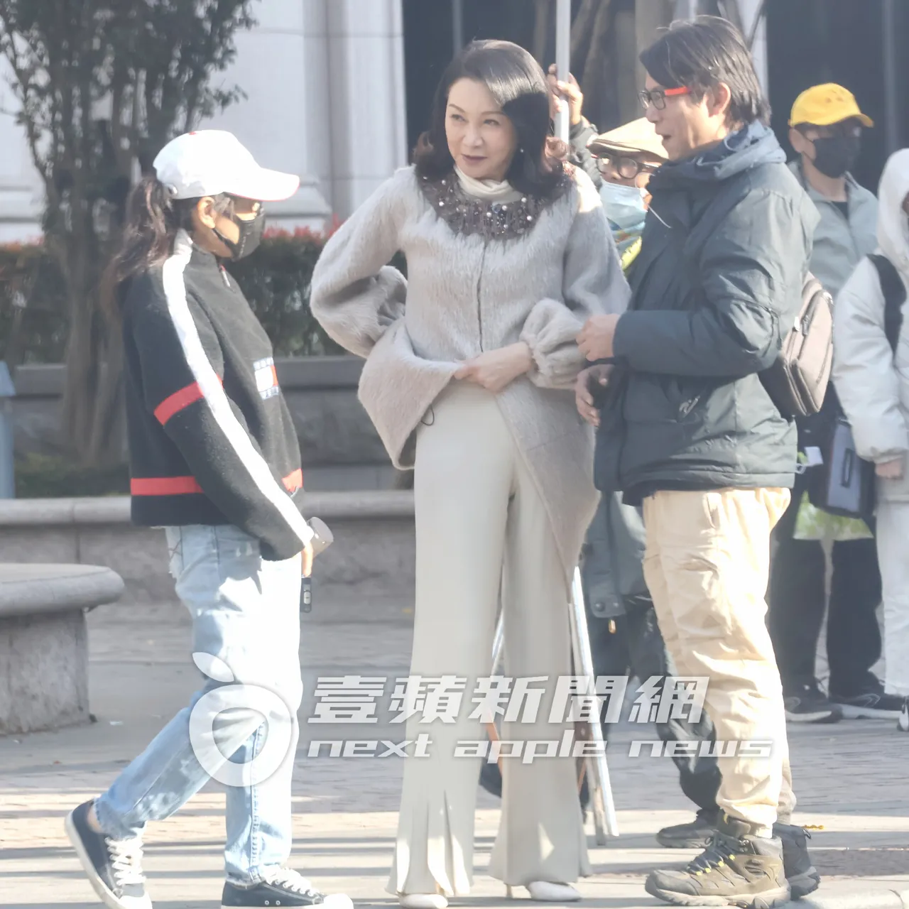 資深藝人張瓊姿(中)收工後,將手伸進背後拿麥克風。特勤中心攝