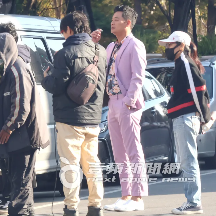 林佑星（中）穿著花襯衫搭配粉紅色西裝，叼根香菸在馬路走來走去。特勤中心攝