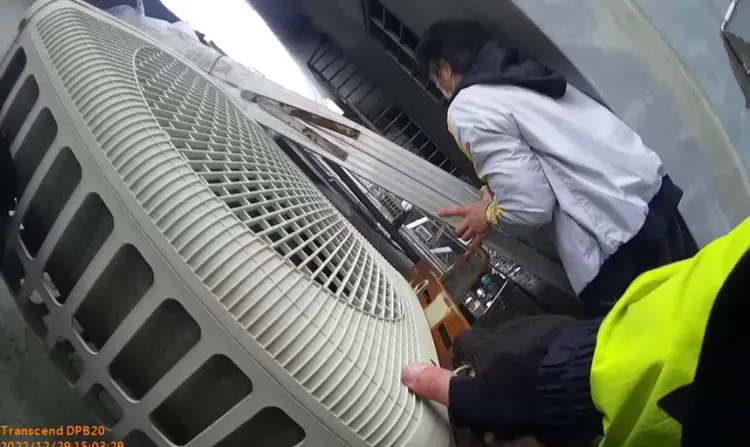 警員架設鋁梯讓女子攀爬下樓。翻攝畫面