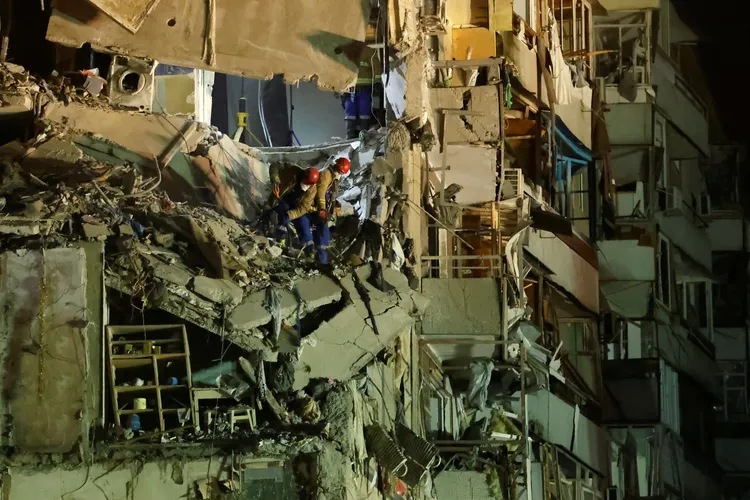 救難人員漏夜搜救可能生還者。路透社