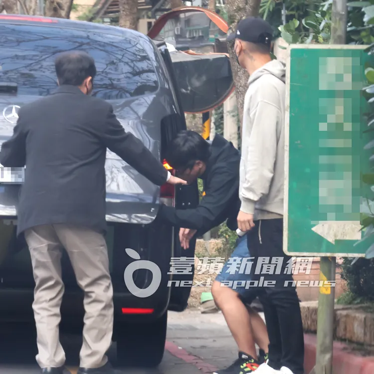 瘦子（右）站在保母車旁，等待助理拿行李。特勤中心攝