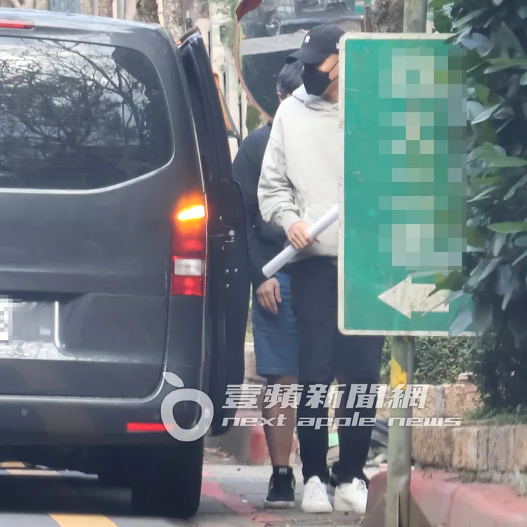 瘦子（右）拿著宣傳海報下車，回到木柵價值4500萬元的透天別墅。特勤中心攝