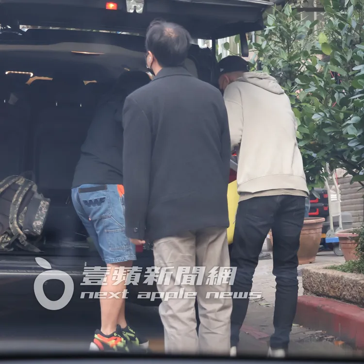 瘦子（右）在後車廂接手助理幫他拿的禮品袋。特勤中心攝