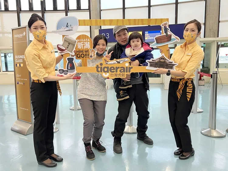 昨旅客開心地與虎妞們合影留念。業者提供