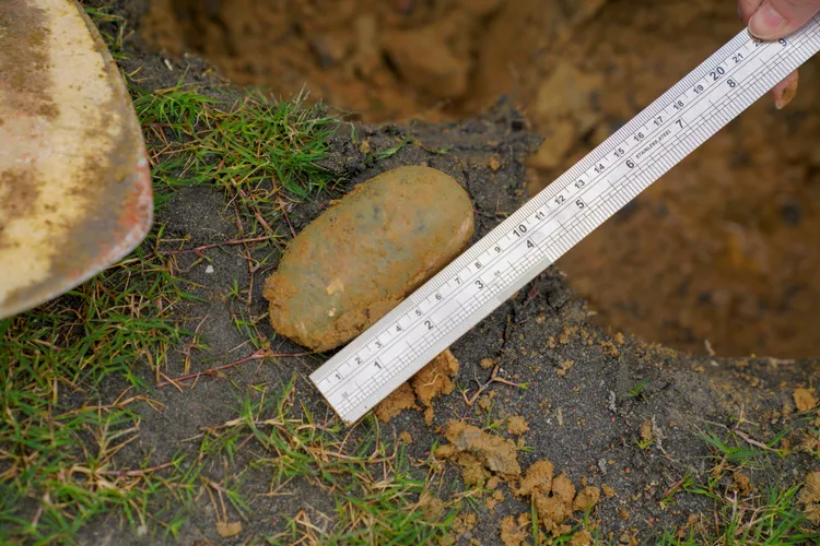 新竹市政府在廢棄電線位置挖掘鄰近處土壤，竟又發現10公分大石頭。新竹市府提供