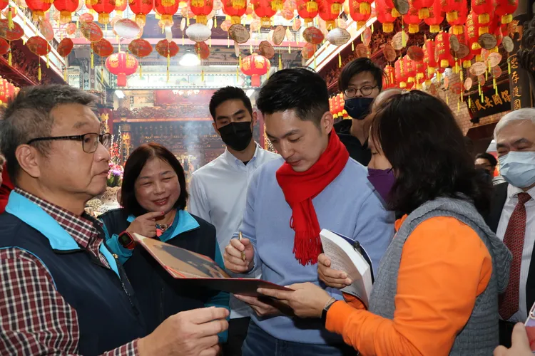 民眾拿書給蔣萬安簽名。鄭孟晃攝