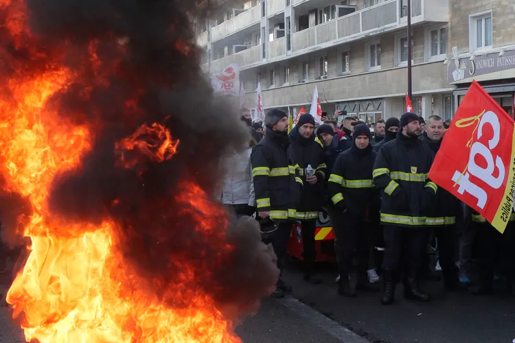 部分抗議民眾點火表達反對年金改革的決心。美聯社