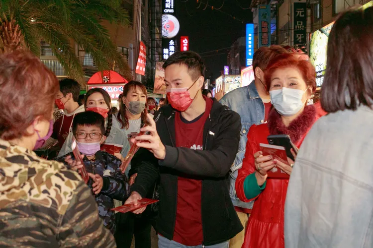 《牛車來去》吳鈴山（中）發紅包袋給民眾，粉絲熱情一路跟隨。公視、禾豐製作提供