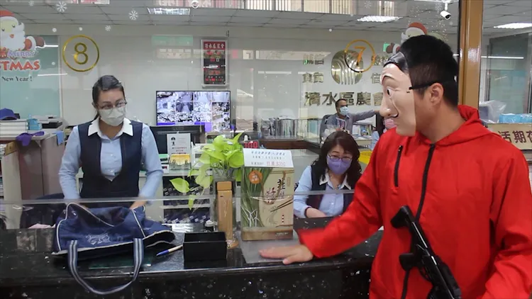 「假歹徒」在櫃檯喝令行員交出現金。警方提供