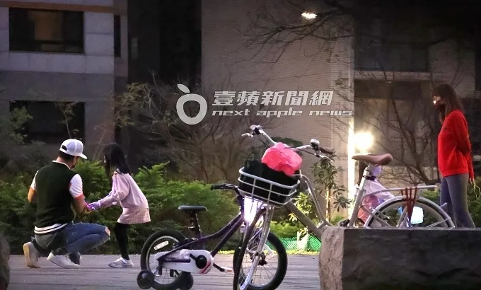 伊正（左）見女兒力氣不夠大，LED彈弓飛箭無法射高飛遠，立刻蹲下安撫女兒。特勤中心攝