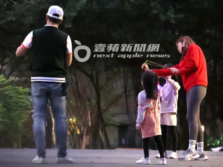 伊正（左起）跟寶貝女兒，認真聽媽媽鄒琳教學如何射LED弓彈飛箭玩具。特勤中心攝