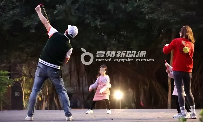 伊正（左）拿起LED彈弓飛箭，猶如后羿射日的動作一般，朝向天空發射。特勤中心攝