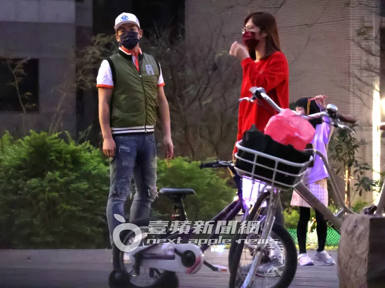 伊正（左）頭載白色棒球帽，身穿短袖polo衫，搭配羽絨背心，跟小16歲的老婆鄒琳帶女兒走春。特勤中心攝