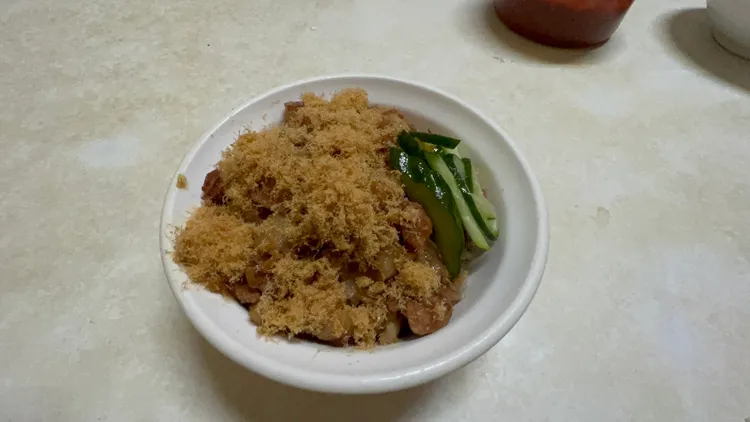 《壹蘋》記者把菜單東西都點了，有米糕、魯蛋，味增湯與油豆腐，總額就是45元，老闆先端上一碗裝到尖尖的米糕、淋上肉燥，還搭配幾片小黃瓜、魚酥，這是店裡最貴的主餐米糕，一碗25元。