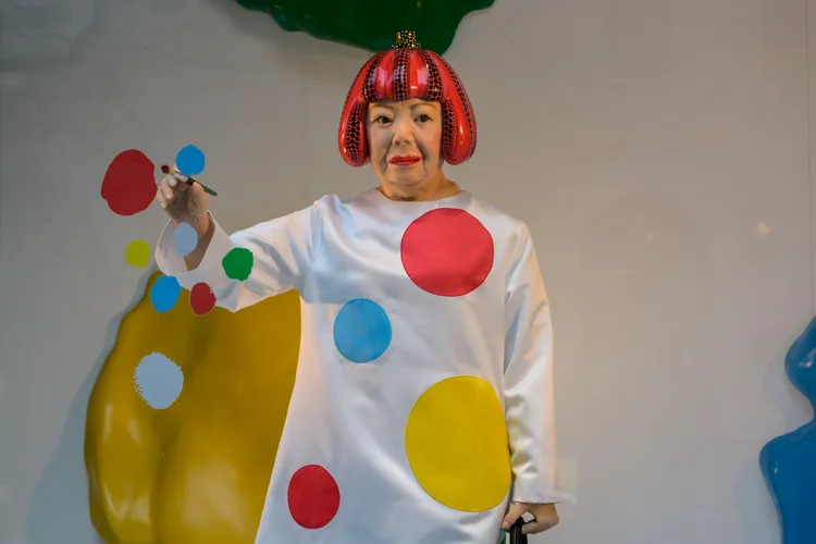 手持畫筆的機器人模擬草間彌生正在作畫的景象。法新社