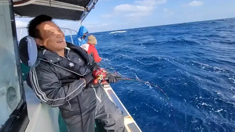 2022年2月4日大年初四獲得頭彩的釣客，與上鉤的紅魽拚搏時笑得合不攏嘴。黃偉提供