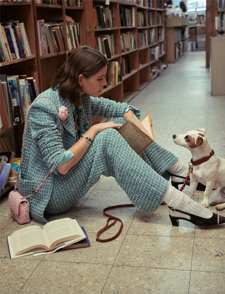 香奈兒2023春夏前導系列當中1套造型借鑑大衛鮑伊的風格為靈感，以綠松色斜紋軟呢外套褲裝搭配後繫帶鞋與對比色的白條紋襪，Vivienne Rohner帶著她的狗狗Skipper一起在書店裡拍攝這套造型。品牌提供