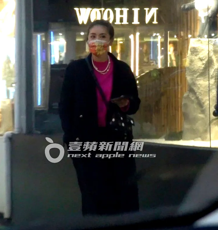 小禎桃紅色上衣搭配黑褲、黑大衣，配戴珍珠及金項鍊點綴，斜背草間彌生包包，走在東區街頭。特勤中心攝