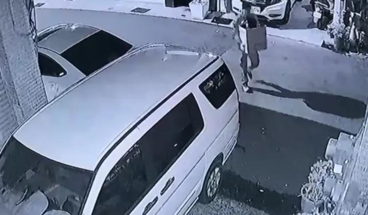 男子把黑色垃圾袋搬到資源回收點，棄置後徒步離開現場。讀者提供