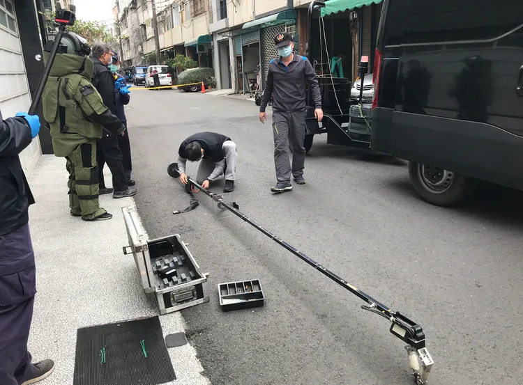 防爆小組到場，使用吊臂將疑似液體炸彈移置到防爆桶。讀者提供