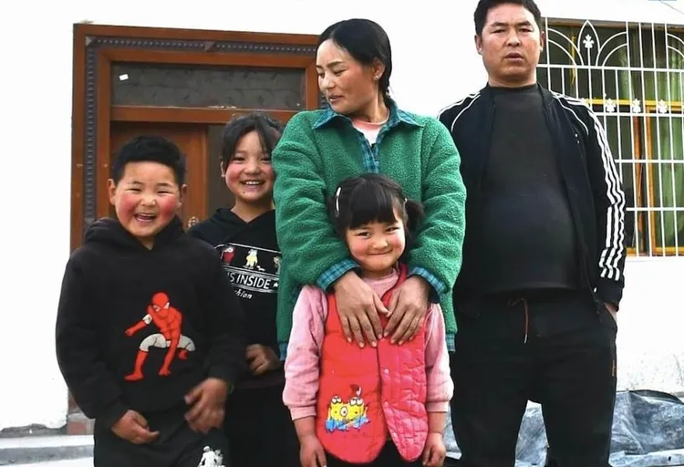 神奇媽媽巴木玉布木已經回到家鄉，與家人一同生活，不再外出打工了。當年襁褓中嬰兒已成為亭亭玉立的少女（左二）。翻攝澎湃新聞