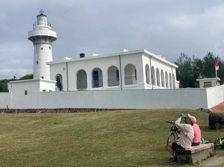 常見遊客在燈塔旁或草地上，邊喝茶邊吃邊聊天，相當悠哉愜意。陳宏銘攝