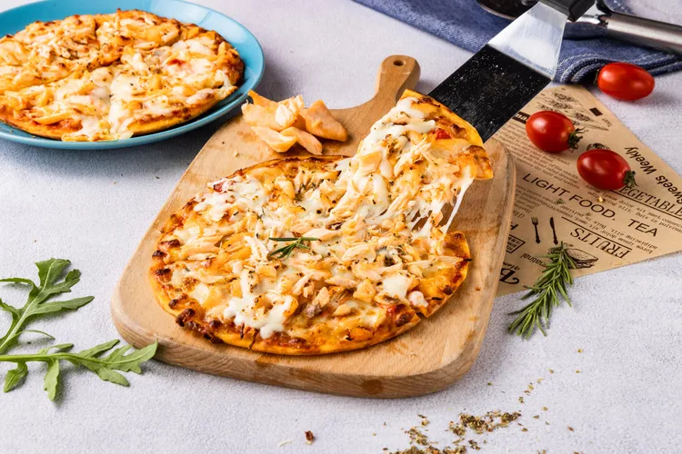 鋪滿鮭魚牽絲出金黃起司瀑布的「美威鮭魚海鮮披薩」，大人小孩都愛。業者提供