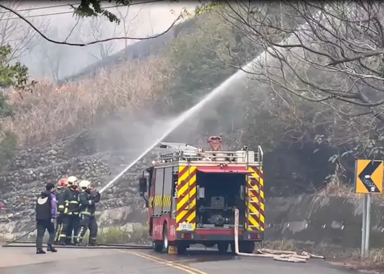 消防人員佈署水線灌救，避免火勢擴大。讀者提供