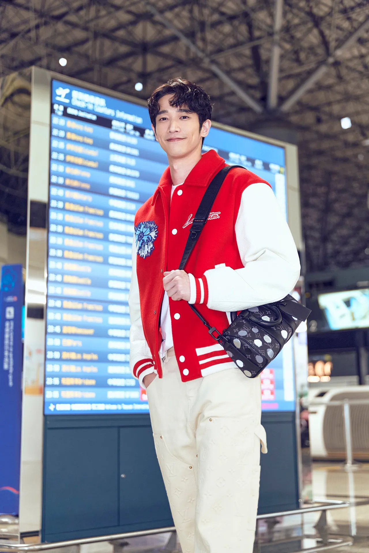 劉以豪穿搭綴有藝術家標誌性的藍色Psychedelic Flower迷幻花朵刺繡紅色棒球外套、Psychedelic Flower迷幻花朵白色上衣，以及綴有立體手繪效果的灰白圓點Keepall 25肩背包，風格輕鬆又亮眼。品牌提供