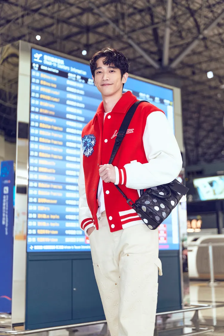 劉以豪穿搭綴有藝術家標誌性的藍色Psychedelic Flower迷幻花朵刺繡紅色棒球外套、Psychedelic Flower迷幻花朵白色上衣，以及綴有立體手繪效果的灰白圓點Keepall 25肩背包，風格輕鬆又亮眼。品牌提供