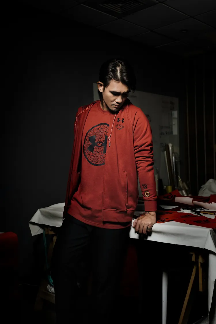 張志豪穿著的UA 新春系列服飾以紅色調與餃子為主要設計圖騰的設計，搭配吸濕排汗等機能，讓訓練者在新春操肌應景卻也不失舒適感。品牌提供