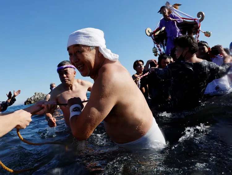 元旦正值隆冬時分，扛著神轎出海的信徒，不少人都光著上身。路透社