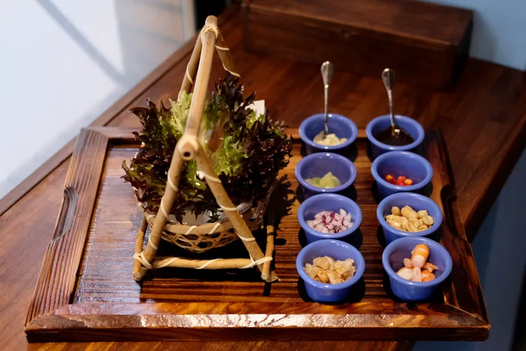 一口泰開胃即是泰國的เมี่ยงคำ這道菜，包含著各式配料，吃法是以生菜包裹著各種料入口。葉盛耀攝