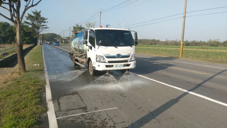 高雄空氣品質差，環保局人員加強加強路面灑水作業。高市府提供