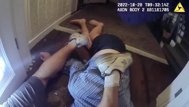 入侵者德裴普被警方壓制在地，保羅（藍色條紋上方者）則被壓在他下方。美聯社