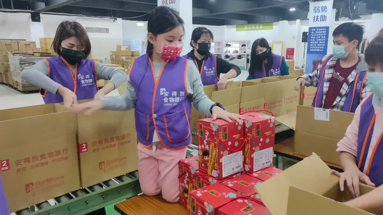許多志工協助包裝食物箱。黃子騰攝