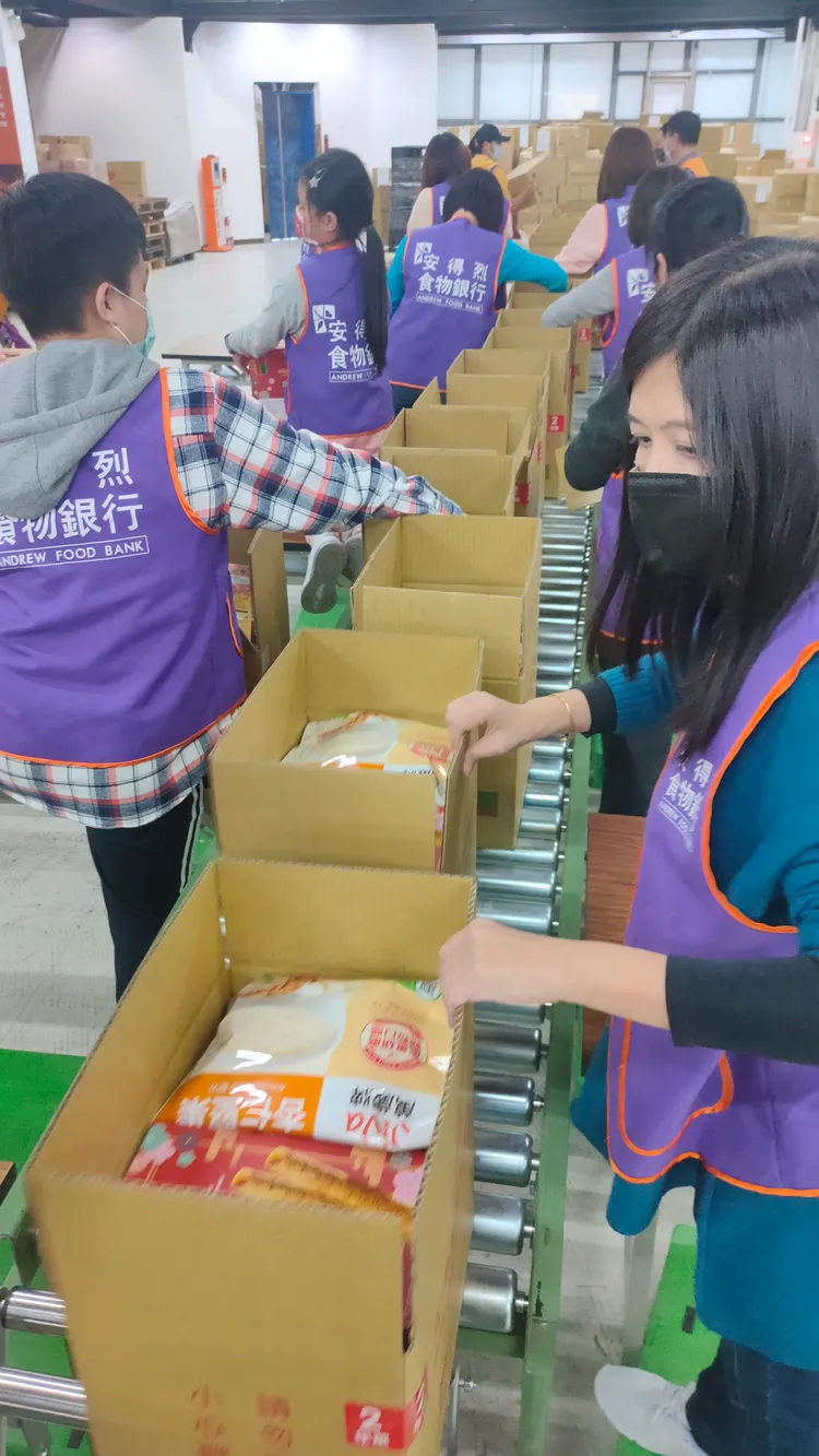多名志工同心協力包裝食物箱。黃子騰攝
