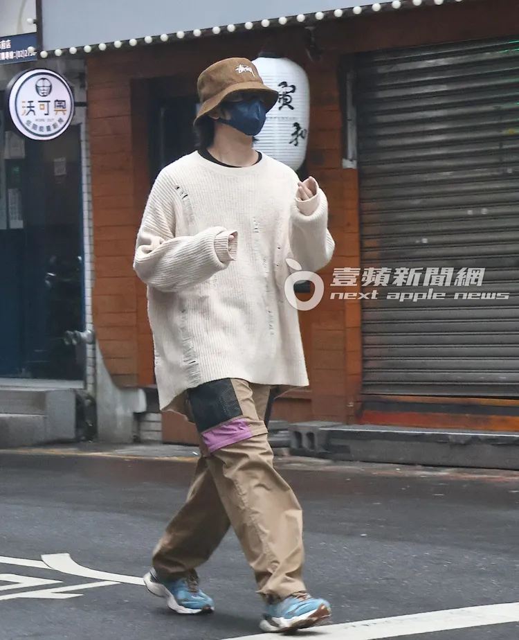 陳柏霖將雙手藏在袖子內，邊走邊甩手。特勤中心攝
